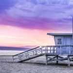 Lifeguard tower on a sandy beach at sunset with colorful sky