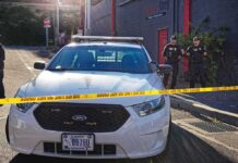 ICE Agent Wasn’t Wearing Body Camera Aaron Guiel near police car behind yellow caution tape