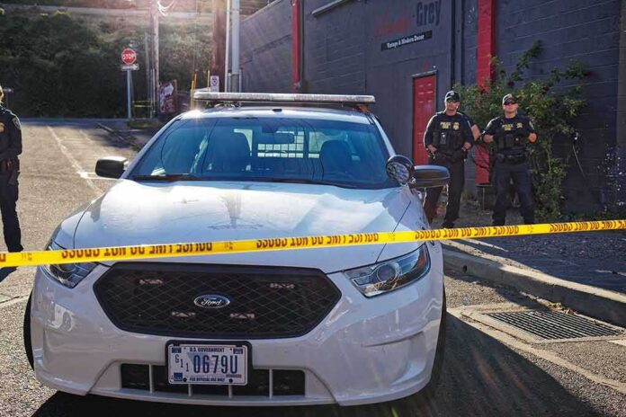 shutterstock_1143336623 Aaron Guiel near police car behind yellow caution tape