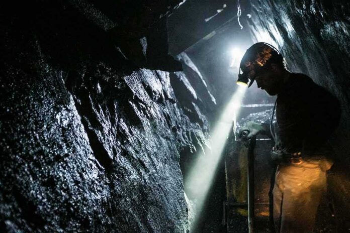 miner with headlamp working in a dark tunnel