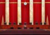 Judge Orders Trump Name Removed Supreme court courtroom with red curtains and empty judges' bench
