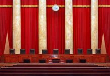 Supreme court courtroom with red curtains and empty judges' bench