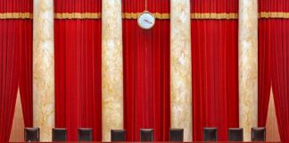 Supreme court courtroom with red curtains and empty judges' bench