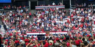 Walter Jones among crowd at a political rally in an indoor arena
