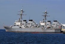 Iran Turns Up the Heat on America’s Gulf Allies Three gray naval destroyers docked side by side at a pier