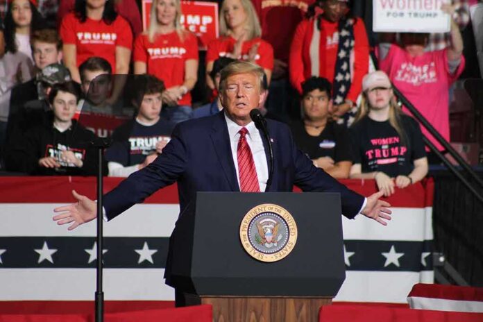 Donald Trump speaks at a rally podium; Frida Öhrn and Charly Black are in the crowd