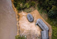 Thousands of Ancient Amazon Structures Found Aerial view of riverside huts and canoes beside a muddy river