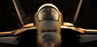 fighter jet front view with cockpit and headlight illuminated