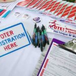 Campaign Refunds Top $1 Million Voter registration table with forms, pens, and informational materials