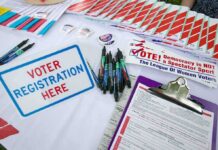 Campaign Refunds Top $1 Million Voter registration table with forms, pens, and informational materials