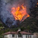 10,500 Acres and Counting: Human-Caused Fire Threatens Reno Wildfire burning on a hillside near homes