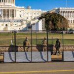 The Fireworks Were Massive. So Was the Security Perimeter. Soldiers stand behind a security fence near a large government building