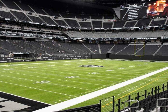 shutterstock_1980596900 American football stadium interior with empty field and stands