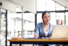 Viral Dating List Hits Business Woman working on a laptop while holding a mug