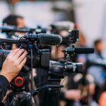 Justice Shaken: DNA Analyst Pleads Guilty in Massive Scandal Video cameras on tripods at a media event