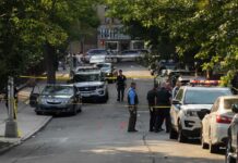 Gunfire Erupts in Downtown Savannah Police officers secure a residential street with patrol cars and yellow tape