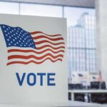 New Jersey Reveals Major Registration Error Voting booth with American flag design in a modern polling place