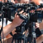 Weapons Arrest at Trump Golf Course television cameras on tripods at a media event