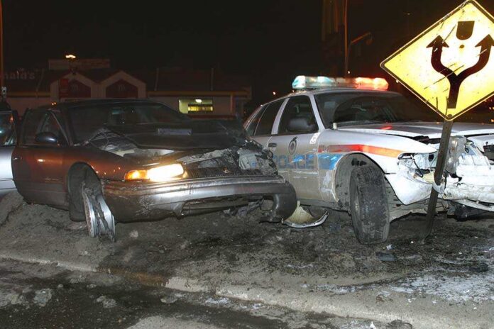 A,Crashed,Police,Cruiser,And,Chase,Car. A damaged car and a police vehicle involved in a nighttime accident