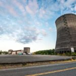 Cooling towers at an industrial power plant under a partly cloudy sky