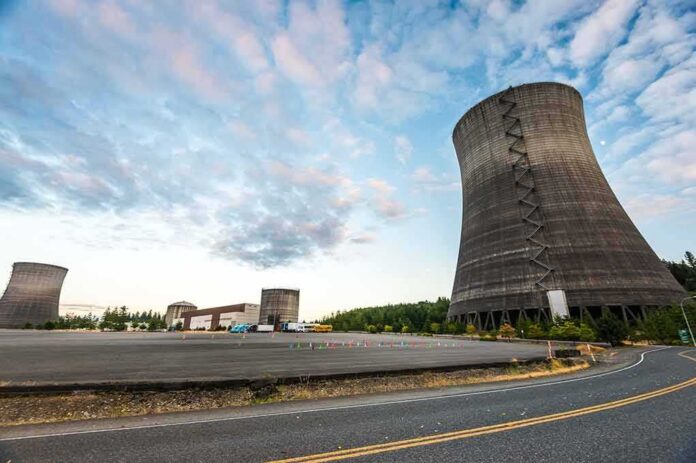 shutterstock_328107353 Cooling towers at an industrial power plant under a partly cloudy sky