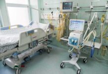Hospital ICU bed with ventilator and monitoring equipment