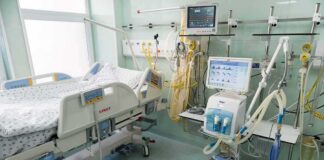 Hospital ICU bed with ventilator and monitoring equipment