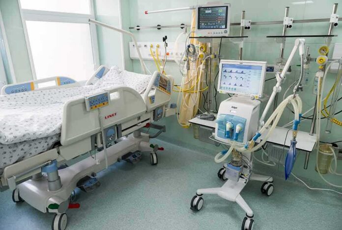 Hospital ICU bed with ventilator and monitoring equipment