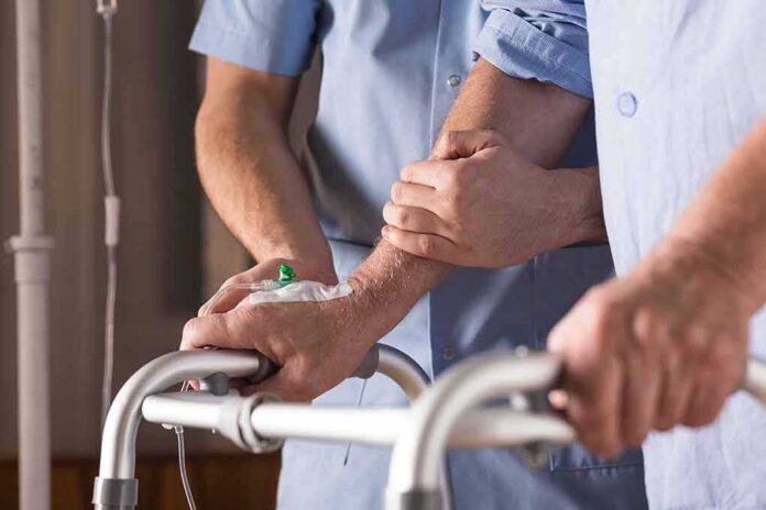 shutterstock_373694485 Elderly person using a walker with caregiver support