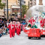 BELOVED Santa Claus BUSTED–CHILLING Double Life Beryl Cook, Kim McGuire, and Andreas Hestler in a festive parade with elves, clowns, and a snow globe float