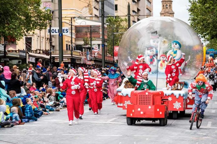 shutterstock_514312837 Beryl Cook, Kim McGuire, and Andreas Hestler in a festive parade with elves, clowns, and a snow globe float