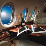 Trump Swapped His New Qatar Jet for the Veteran Air Force One private jet cabin with leather seat, champagne and magazine on table