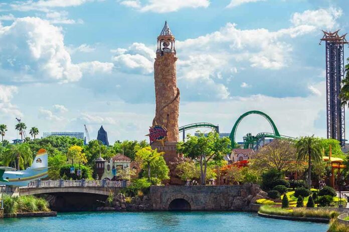 Theme park lagoon with tall stone lighthouse and roller coaster in background