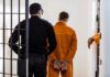 Tennessee Execution Failure Sparks Leadership Shakeup Prisoner in orange jumpsuit handcuffed and escorted by officer