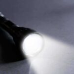 Southern California Urged to Save Power Flashlight shining a bright beam on a dark surface