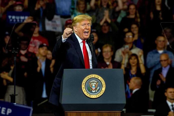 Donald Trump speaking at a rally behind a presidential podium