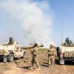 Soldiers with two military vehicles during field exercise