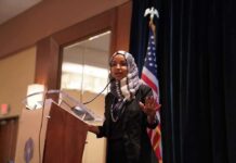 Lawmaker Faces Classified Leak Allegations Ilhan Omar speaking at a podium with a microphone