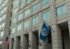 Flag Protest Leads to Immigration Detention U.S. government building facade with American and blue departmental flags