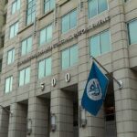Flag Protest Leads to Immigration Detention U.S. government building facade with American and blue departmental flags