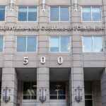 Unlawful Presence Can Mean Deportation, Official Says US government building facade with flags and number 500