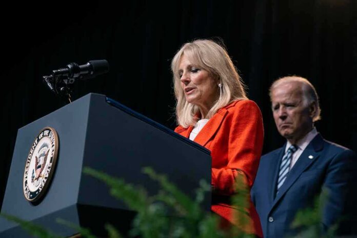 shutterstock_1670191699 Jill Biden speaks at a podium as Joe Biden stands behind her