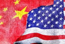Chinese and American flags torn and overlapping