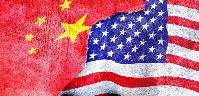 shutterstock_1772231144 Chinese and American flags torn and overlapping