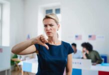 Woman giving a thumbs-down gesture at a polling place