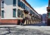 Mother Reports Man Harassing Children Near Storm Drain Row houses along a cobblestone street in an urban setting