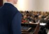 A speaker at a podium addressing an audience