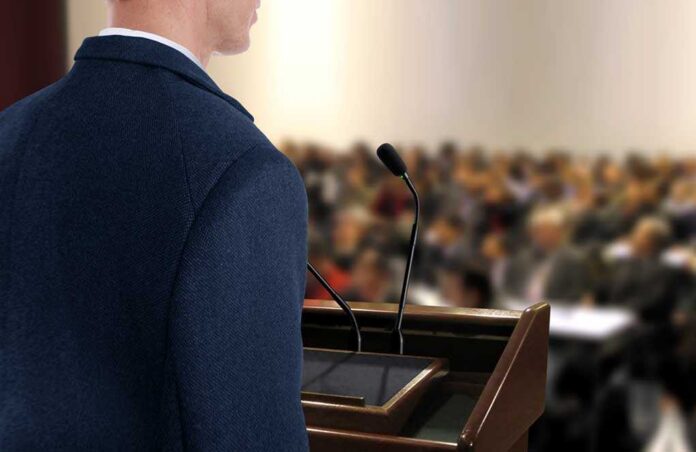 Speaker,At,Seminar,Presentation A speaker at a podium addressing an audience