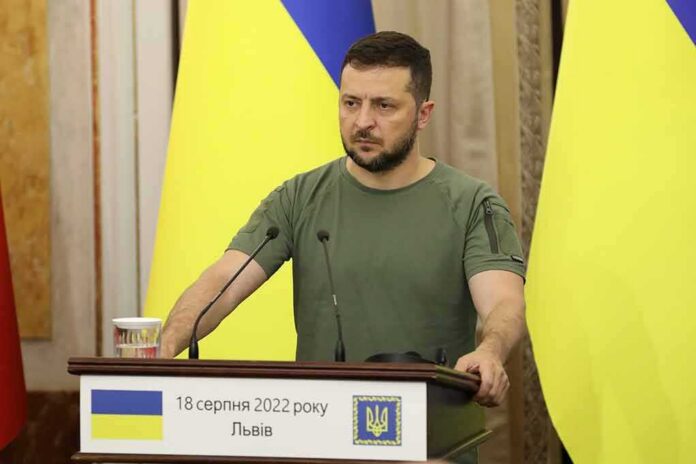 shutterstock_2197413383-1 Man at a podium with Ukrainian flags