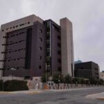 Parole Decision Sparks Outrage Over The Case Modern concrete and dark glass government building on a cloudy day